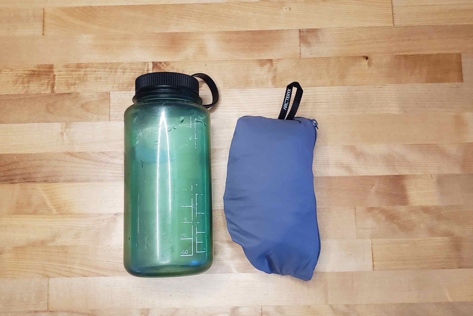 A packed windbreaker compared to a water bottle.