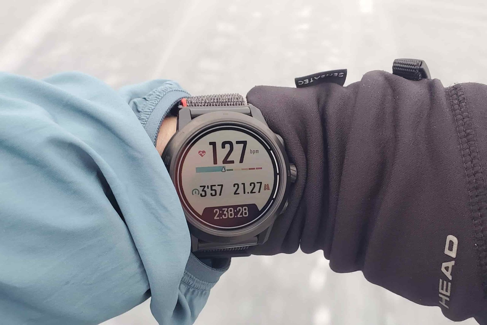A closeup of a watch worn on the wrist showing performance metrics.