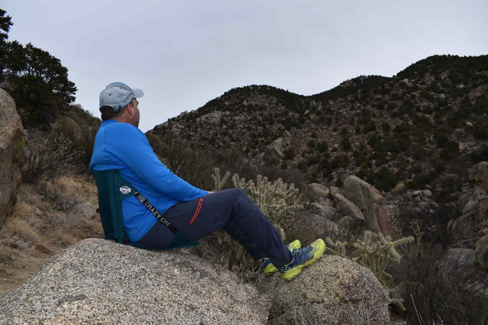 hiker sits on the Crazy Creek Hex 2.0 on a bolder for extra cushioning and a back rest