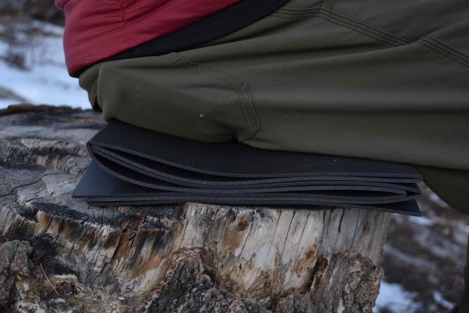 close up of a backpacker sitting on the folded Thinlight Pad