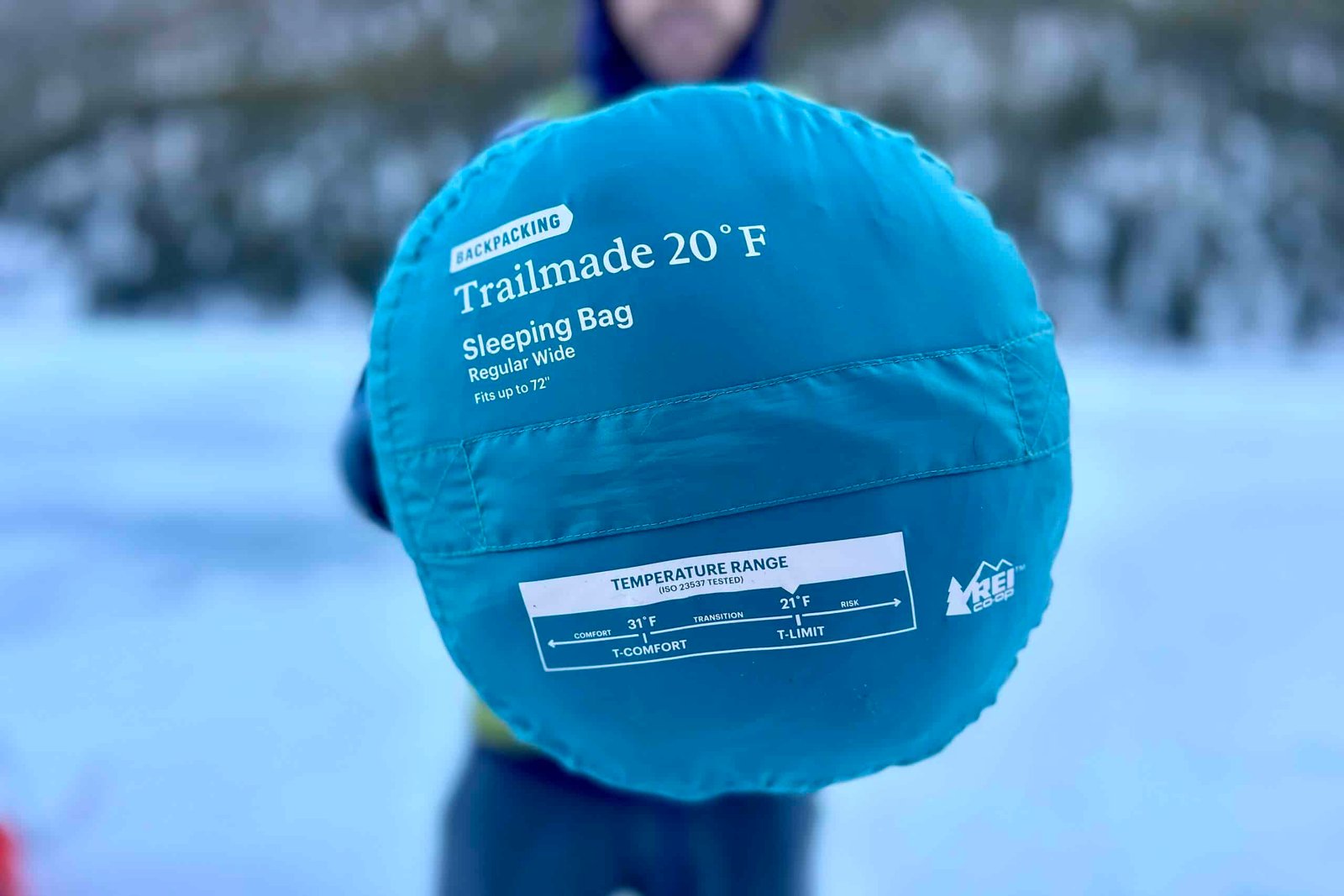 Close up image of a sleeping bag in a stuff sack from the bottom, showing off the temperature range and name logo.