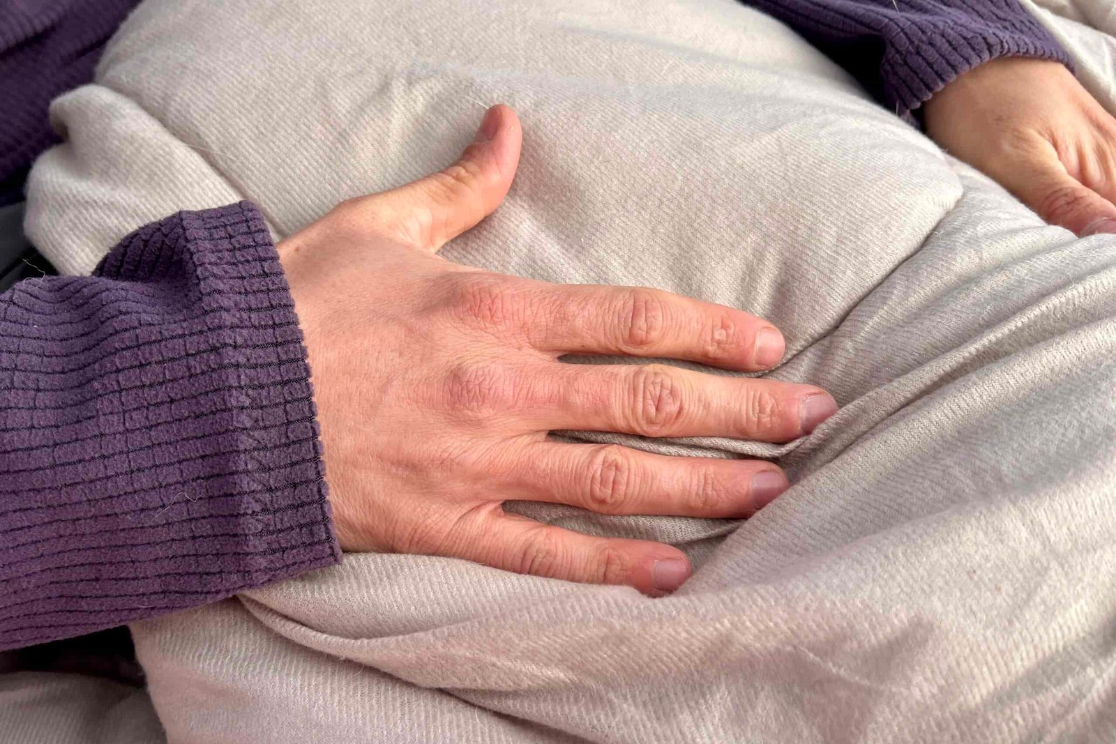 Close up image of a hand on the cushy interior fabric of a sleeping bag.