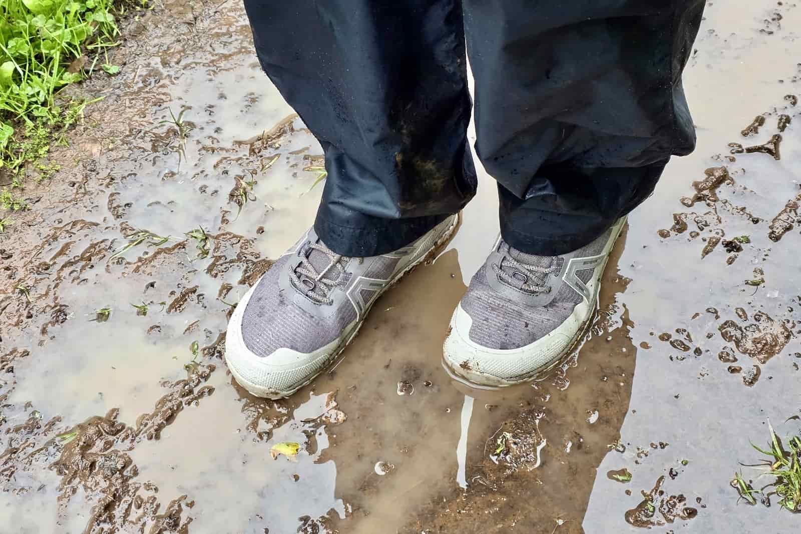 Person standing in a mud puddle wearing Xero Shoes.