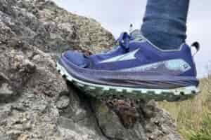 Close up showing the Altra shoe while climbing up a rock