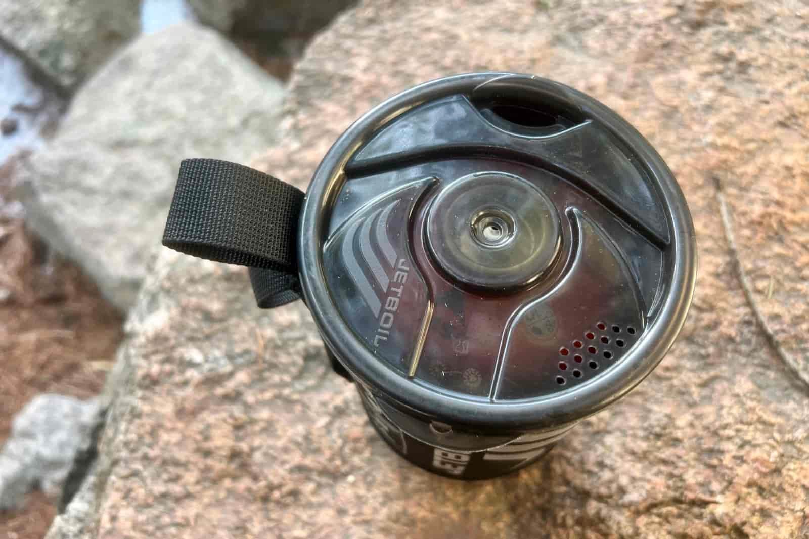 A top down view of the jetboil flash on a rock with the lid on and fuel packed inside