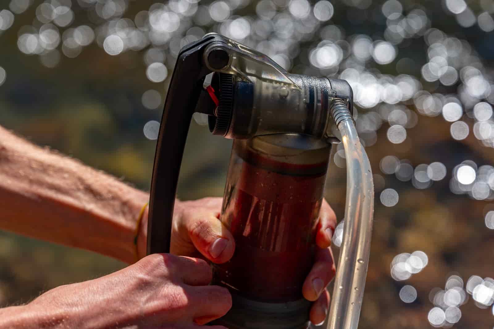 A close up of a hiker pumping with the msr guardian filter