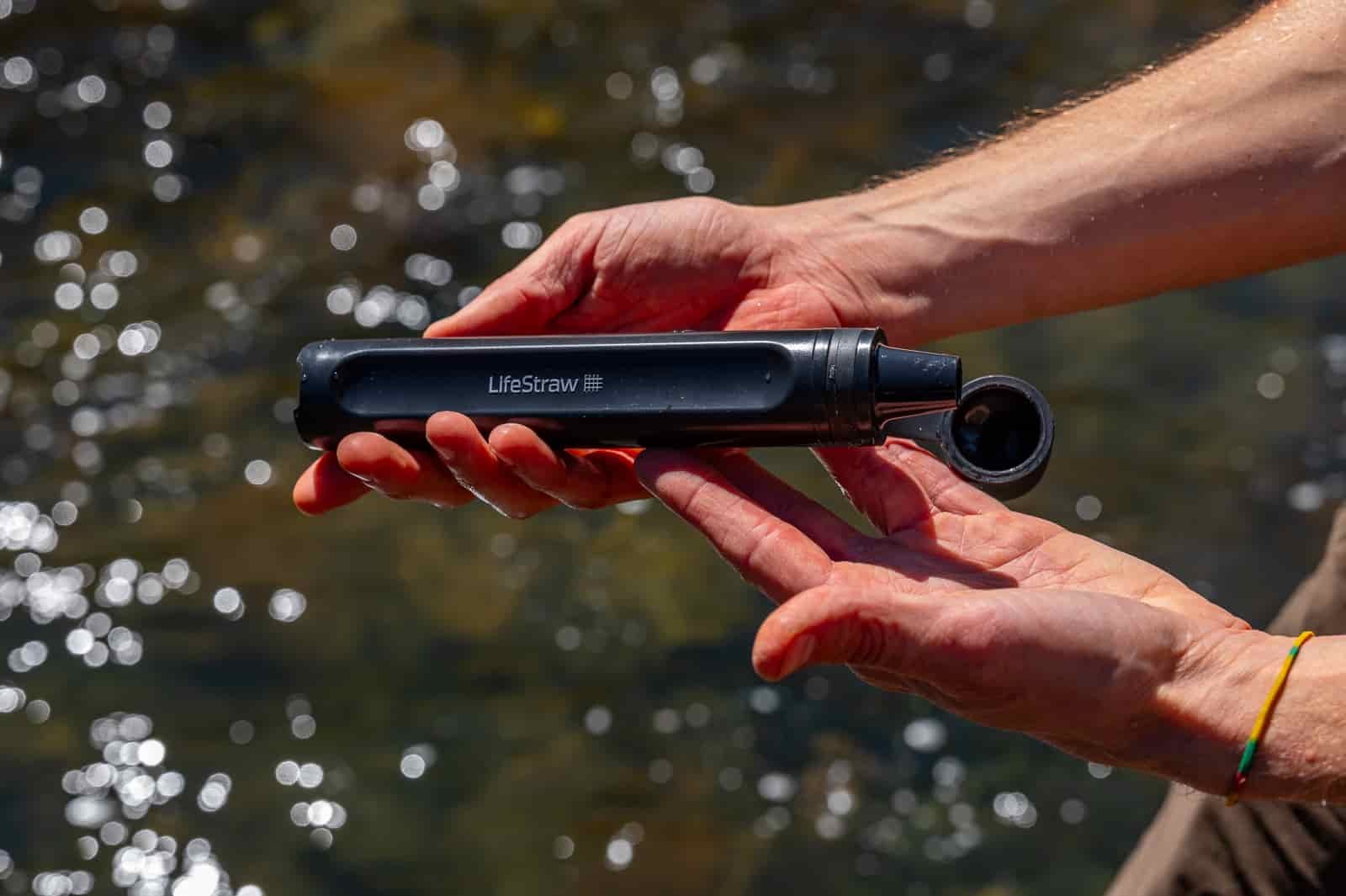 A close up of hands holding a straw water filter