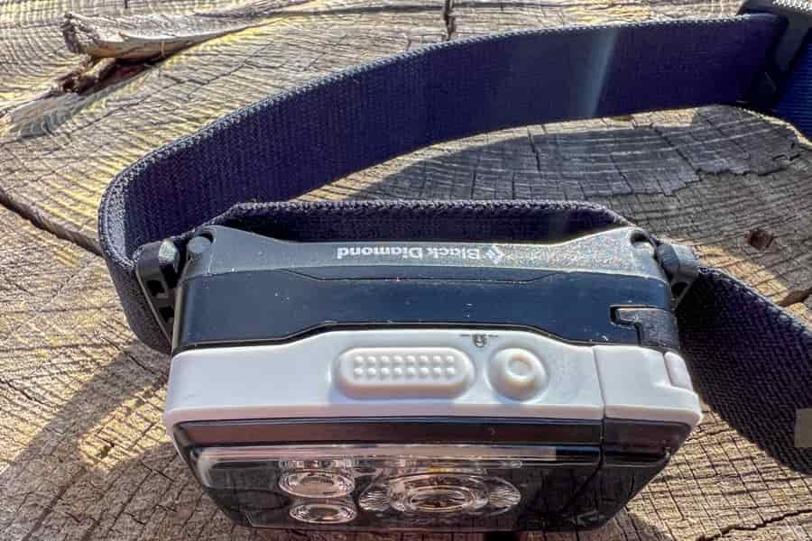A view from above of the Black Diamond Distance LT1100. The headlamp is sitting on a tree stump.