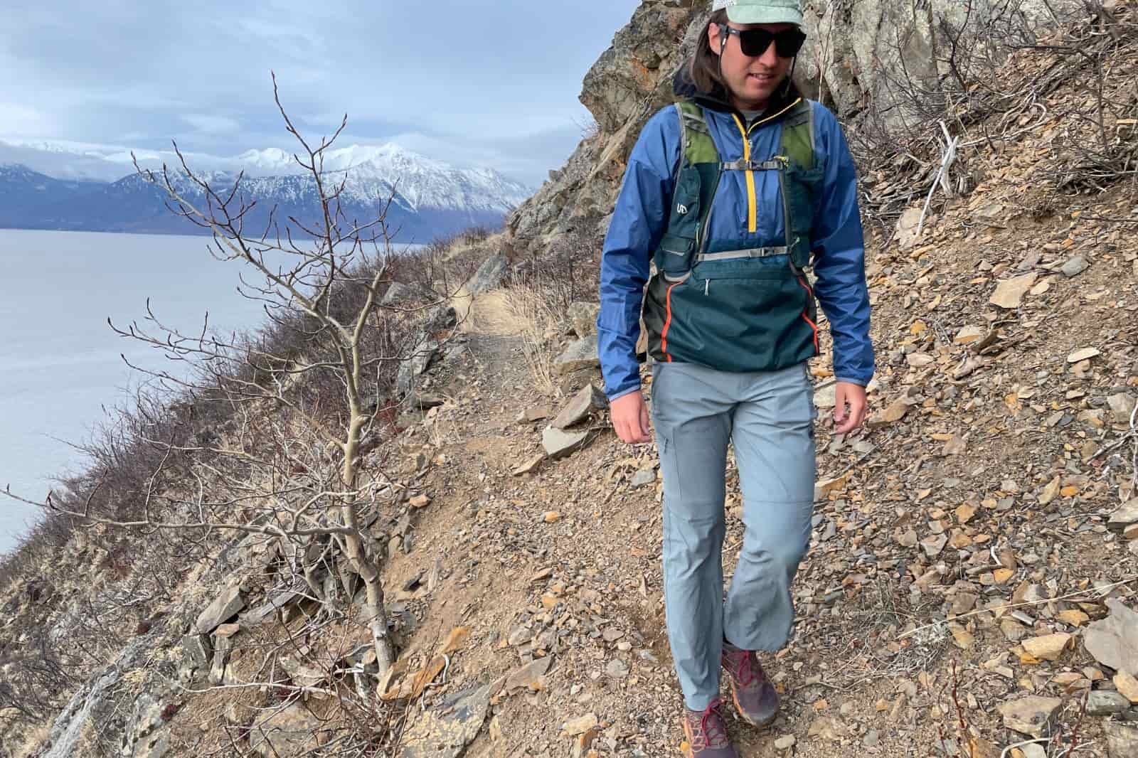 A man hikes along a narrow mountain trail.