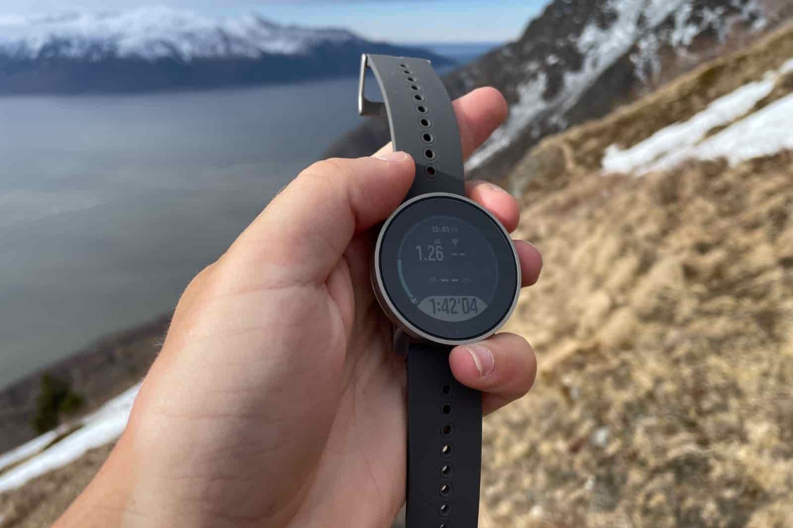 A closeup of a watch face with a mountain background.