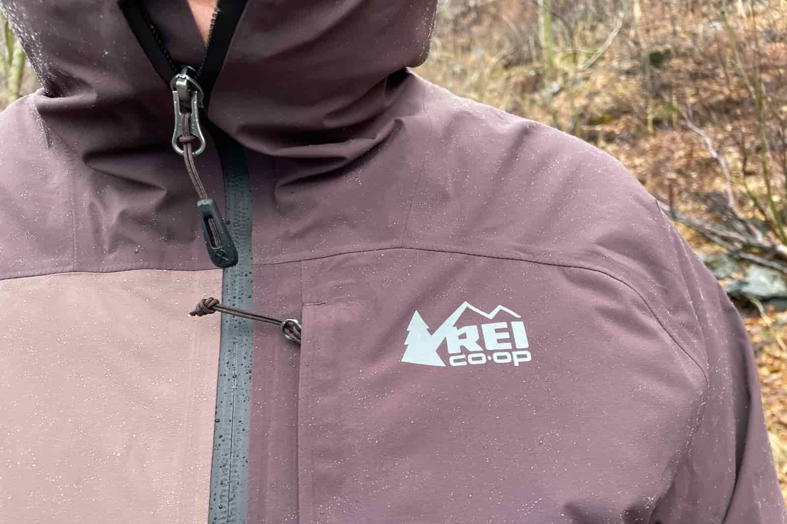 A closeup of the logo of a rain jacket with rain on it.