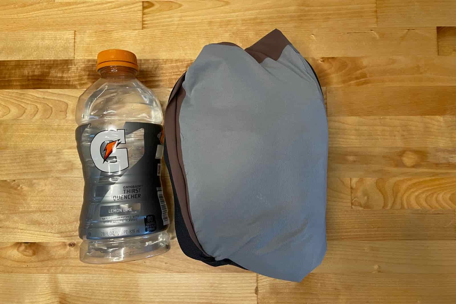 A packed rain jacket compared to a one liter bottle.