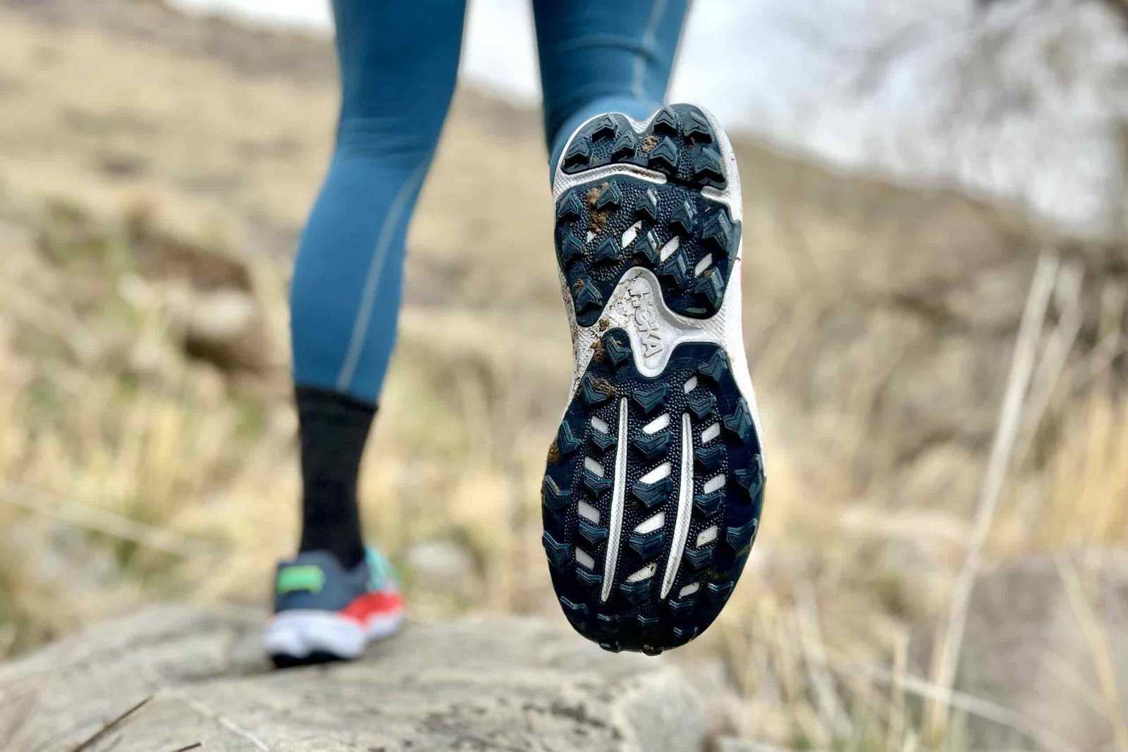 Close up image of the bottom of a pair of trail running shoes, showing the lug pattern.