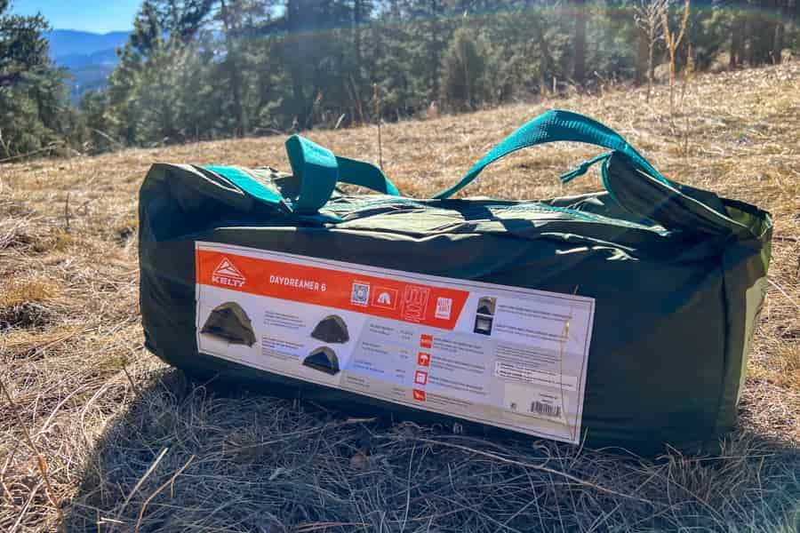 The fully packed up Kelty Day Dreamer 6 tent side in a filed of brown grass.