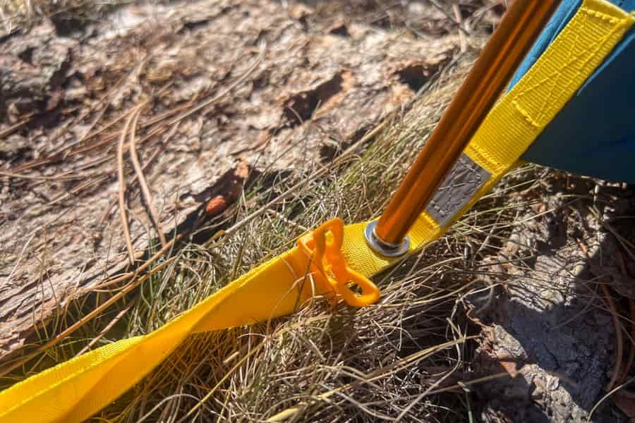 A yellow tent pole placed inside a yellow grommet.