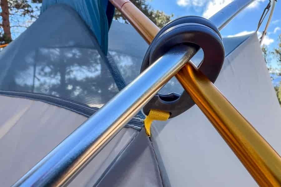 A closeup of two tent poles secured together with a black plastic clip.