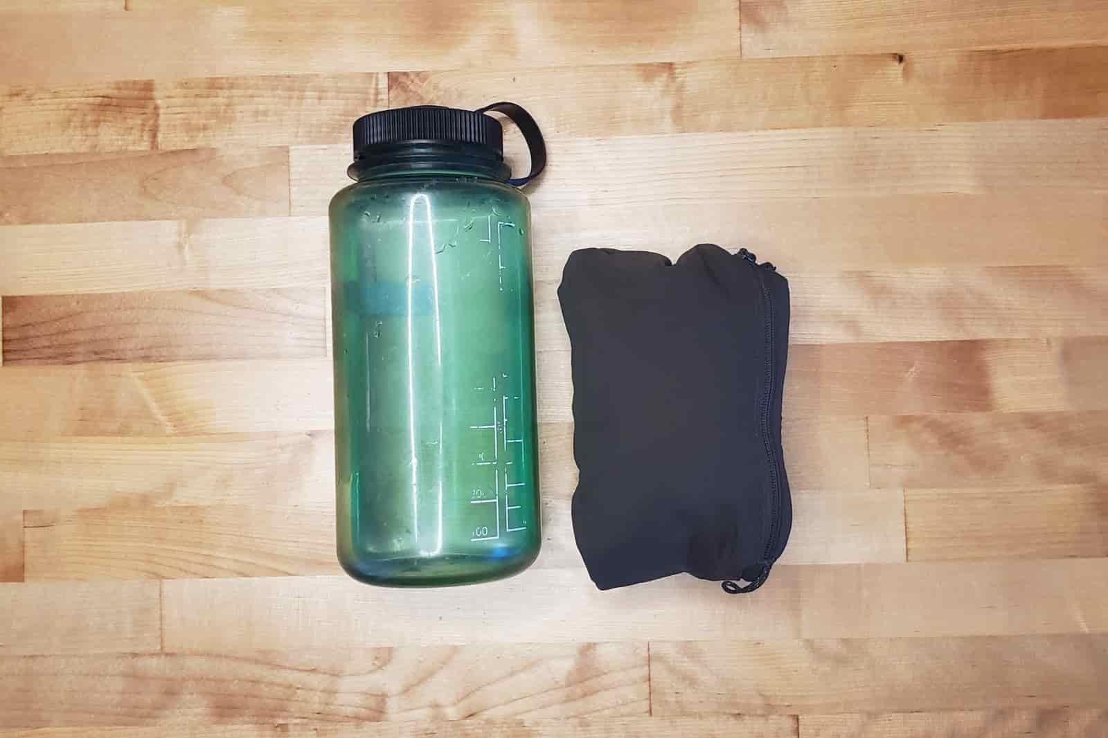 A packed windbreaker compared to a one liter bottle.
