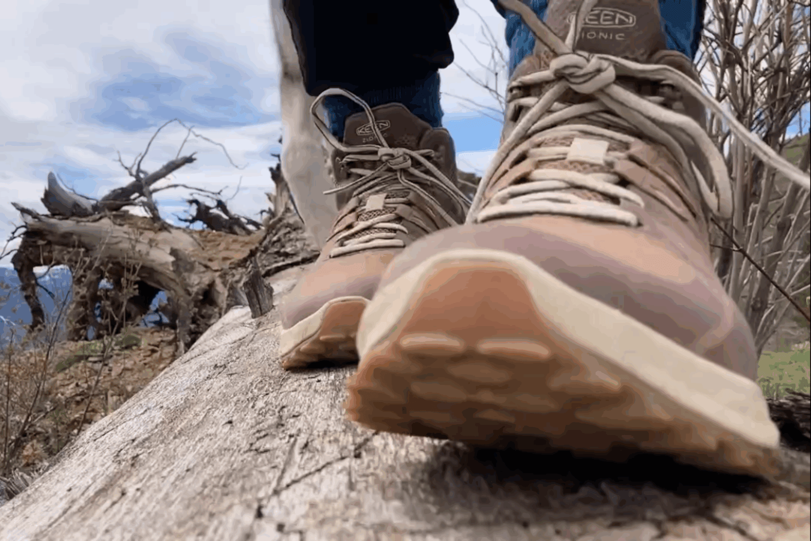 Hiker standing on a log wearing the Keen Zionic Waterproof Women’s Hiking Boots