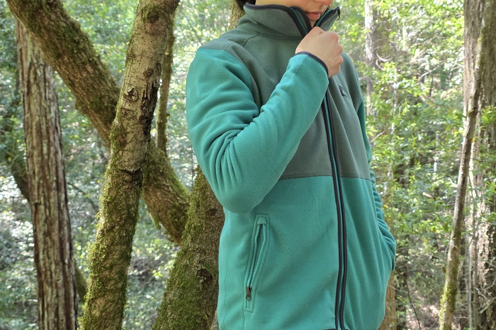 Close up of a woman zipping up her fleece jacket.
