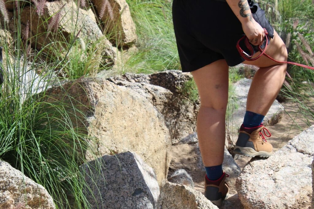 Hiker walking her dog on a desert trail while wearing the Columbia Newton Ridge Plus Waterproof Amped