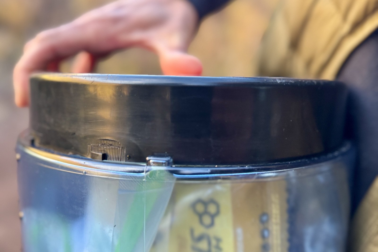 a close up of a bear canister's lid and locking mechanism