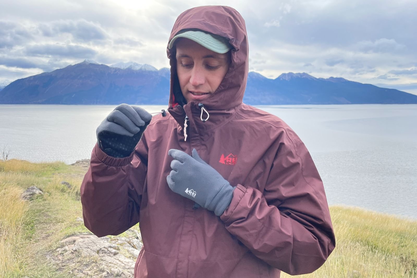 A man tightens down the hood on his jacket.