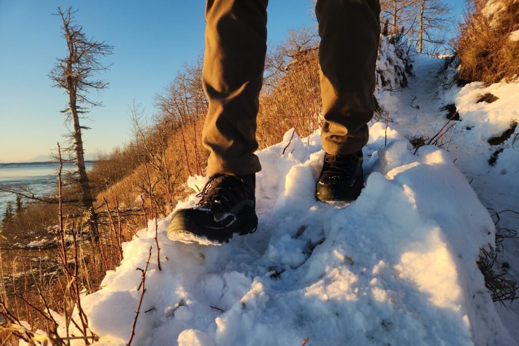 A closeup of winter boots walking down a steep hill.