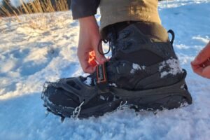 A closeup of traction devices being added to winter boots.